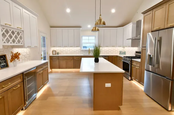 a kitchen with stainless steel appliances granite countertop a refrigerator a sink a stove and a refrigerator