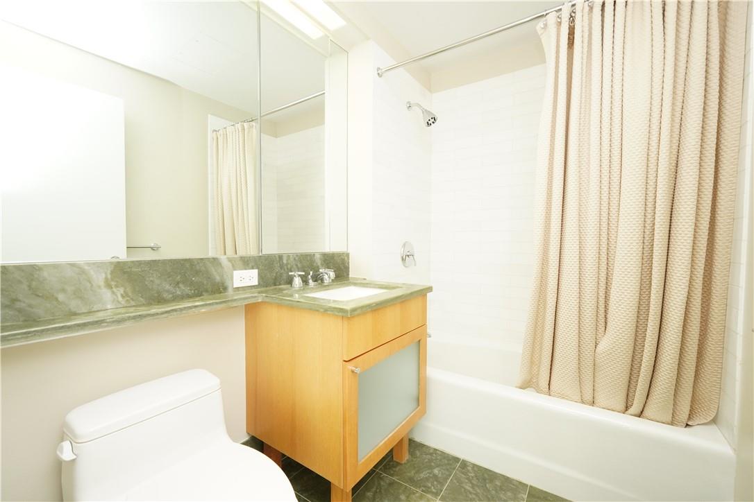 207 East 57th Street, Unit 21B Manhattan, NY 10022 - Photo 9 of 12 a bathroom with a sink a toilet and a bathtub