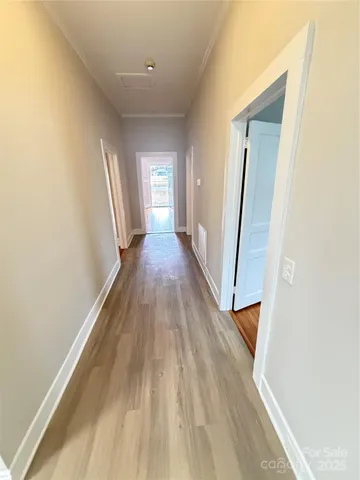 a view of a hallway with wooden floor