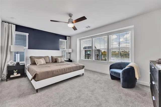 a spacious bedroom with a bed and a large window