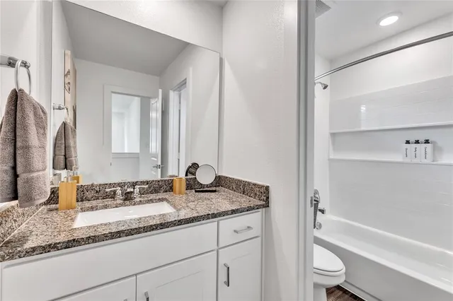 a bathroom with a granite countertop sink and a mirror