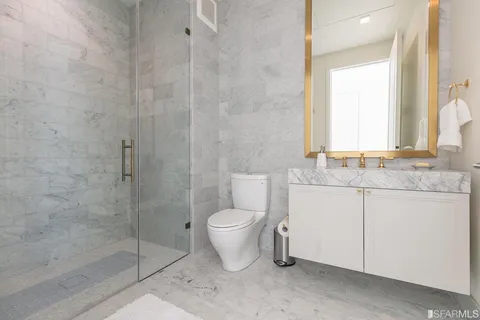 a bathroom with a granite countertop toilet a sink and a shower