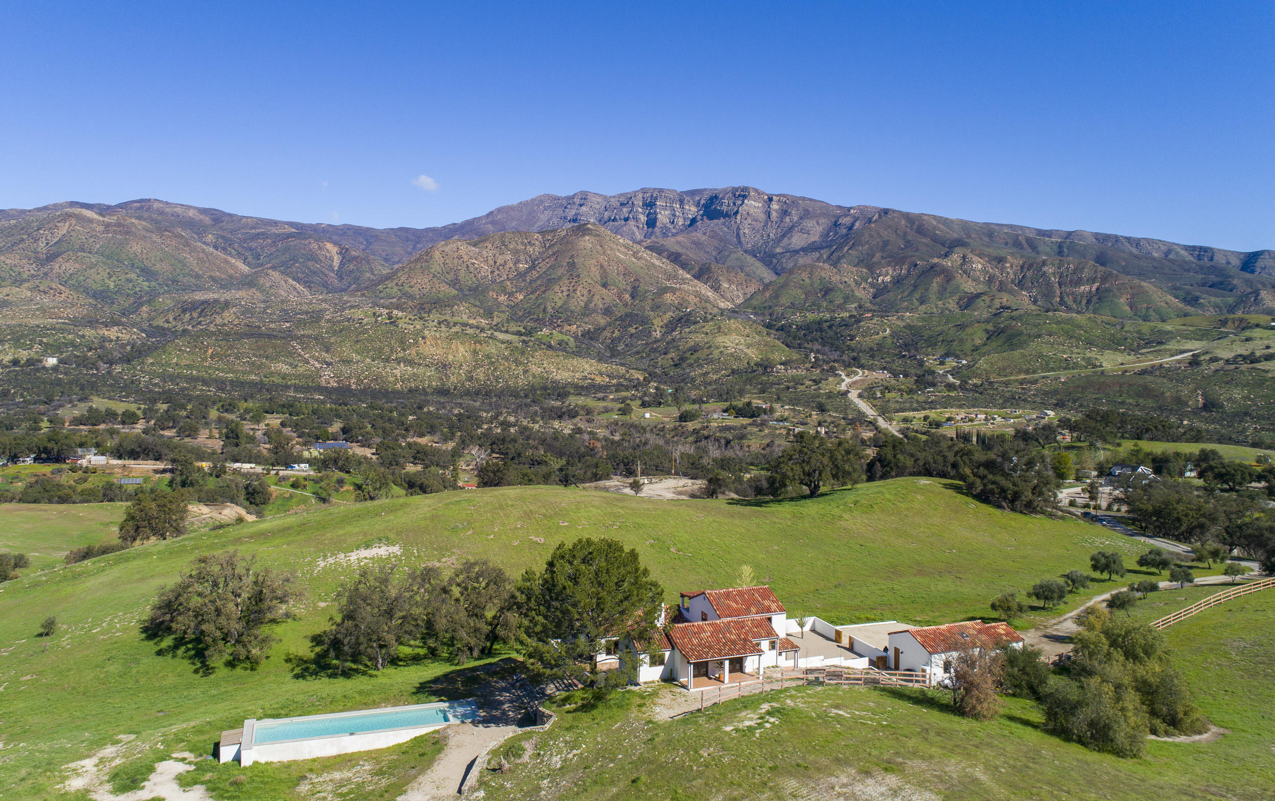an aerial view of a houses with a yard and lake view