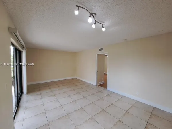 an empty room with fan and entrance