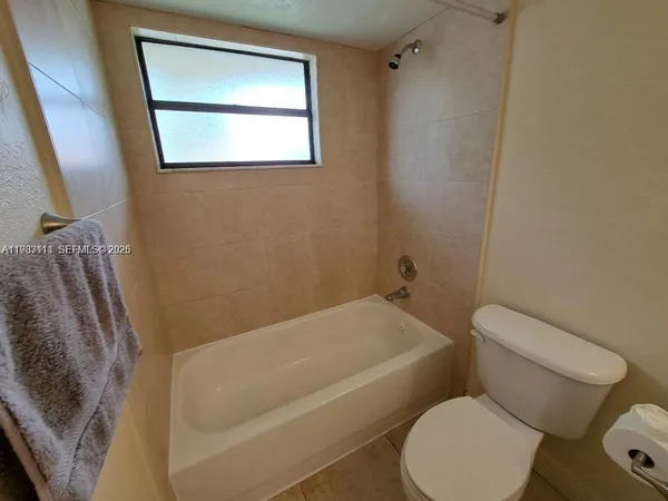 a white toilet sitting next to a bath tub