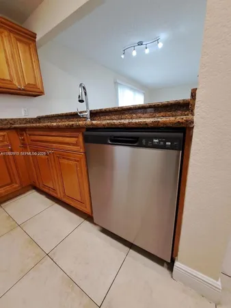 a kitchen with granite countertop a sink and a stove top oven