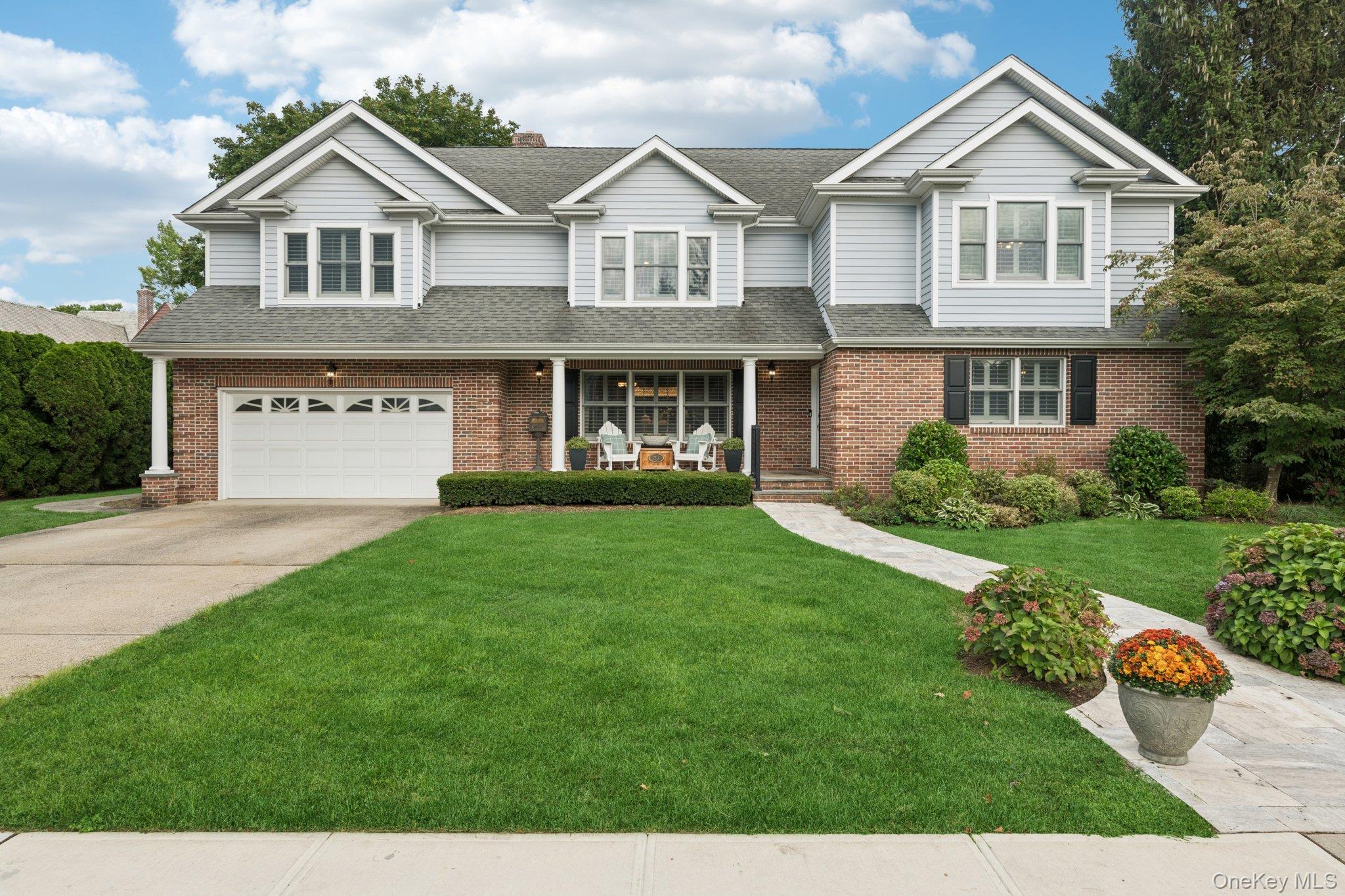 front view of house with a yard and many windows