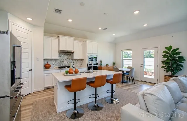 a living room with furniture a dining table and kitchen view