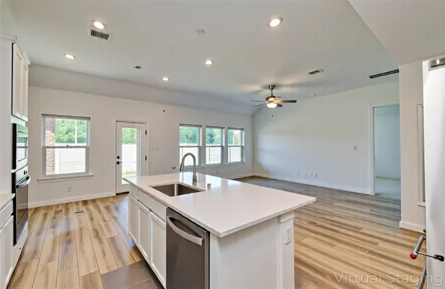 a living room with furniture a rug potted plant and a large window