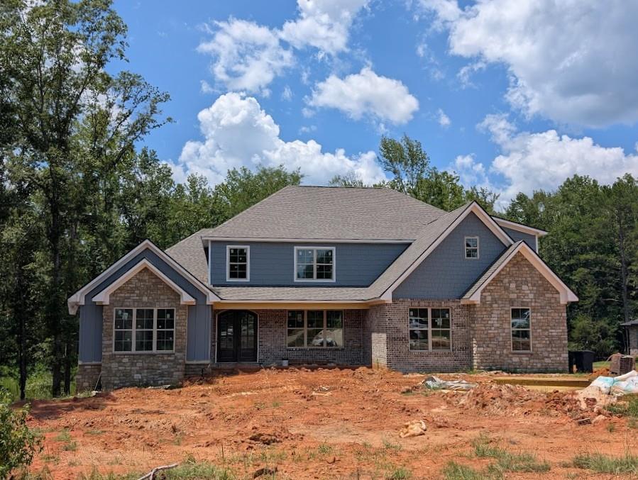 a front view of a house with a yard covered in snow
