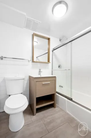 a bathroom with a toilet a sink and mirror