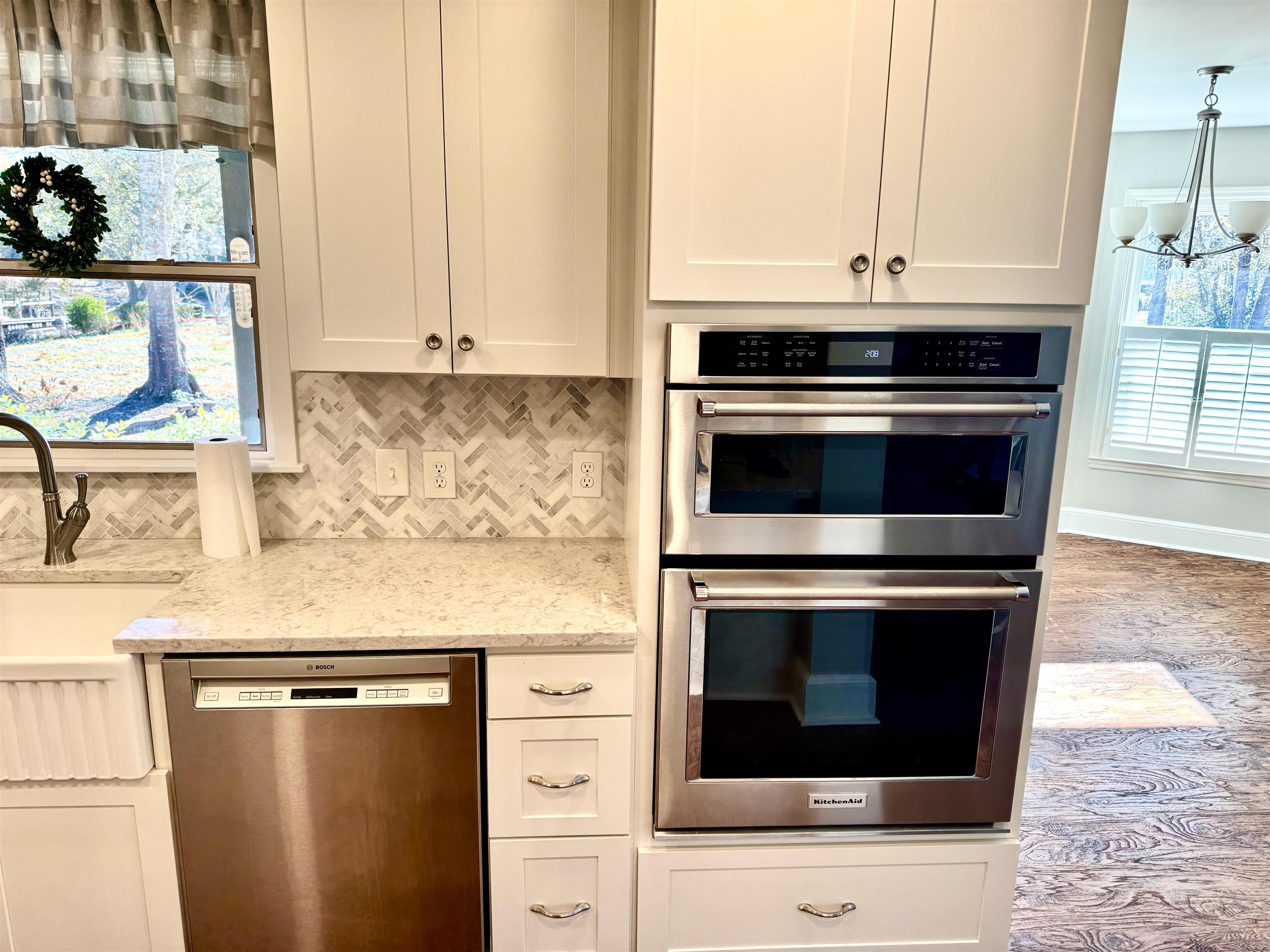 94 John Green Lane Georgetown, SC 29440 - Photo 3 of 35 Kitchen with stainless steel appliances, a chandelier, light stone countertops, white cabinets, and tasteful backsplash
