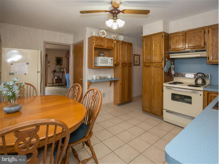 5 Evergreen Road Stratford, NJ 08084 - Photo 5 of 18 a kitchen with stainless steel appliances granite countertop a dining table chairs refrigerator and sink