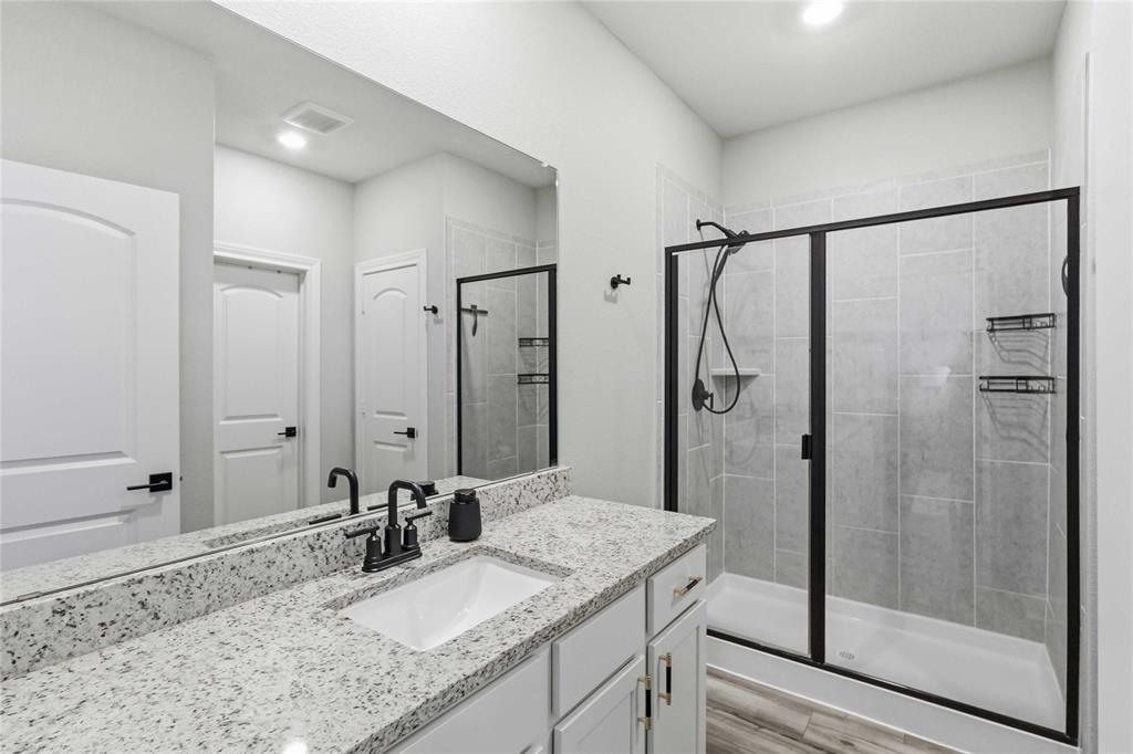 1012 Calhoun Drive Anna, TX 75409 - Photo 29 of 39 Modern bathroom featuring a single vanity with a granite-style countertop and an integrated rectangular sink