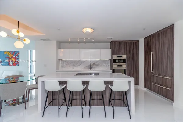 a kitchen with a dining table chairs and white cabinets