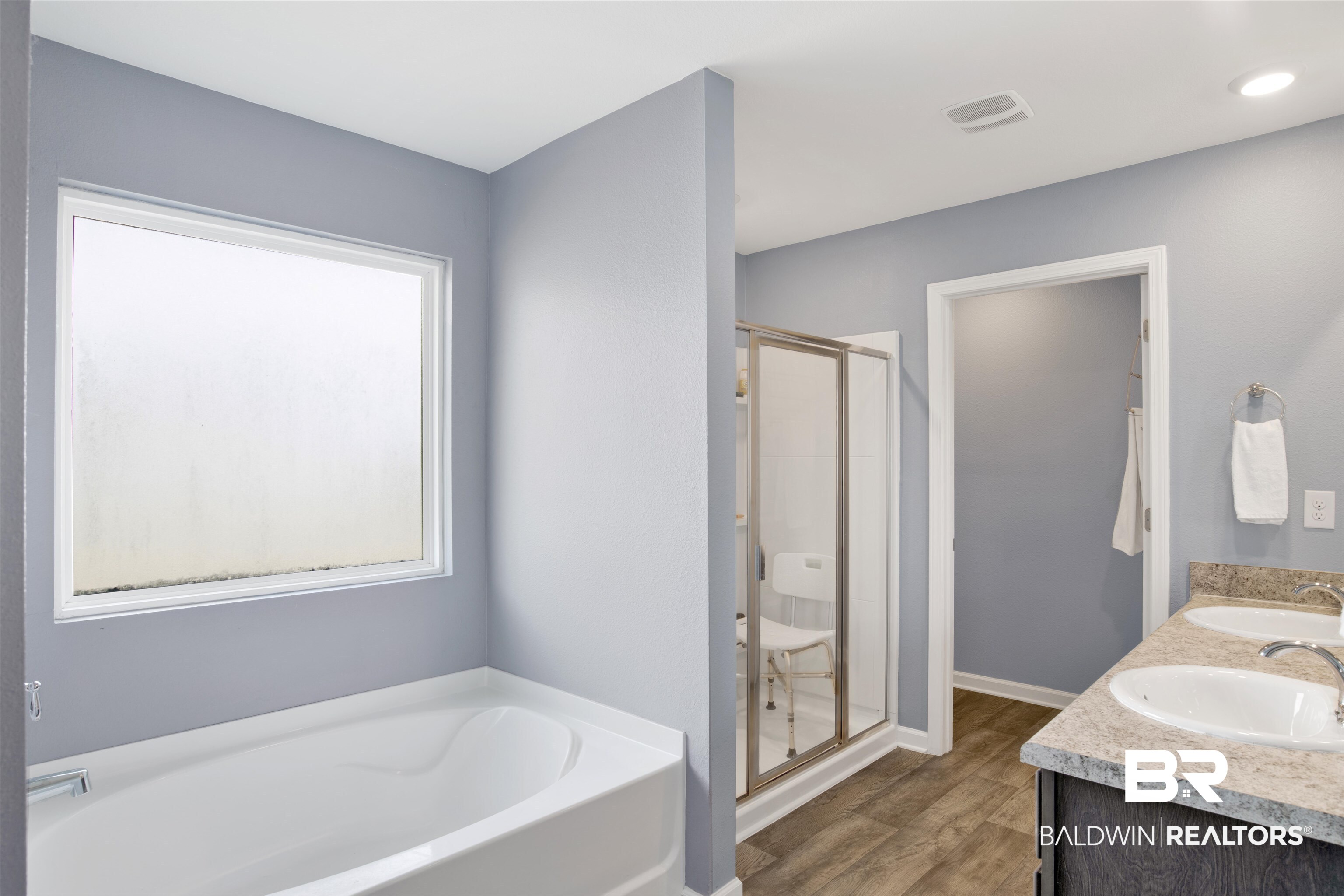 304 Hartenstein Road Foley, AL 36535 - Photo 23 of 28 Bathroom with vanity, hardwood / wood-style floors, and plus walk in shower
