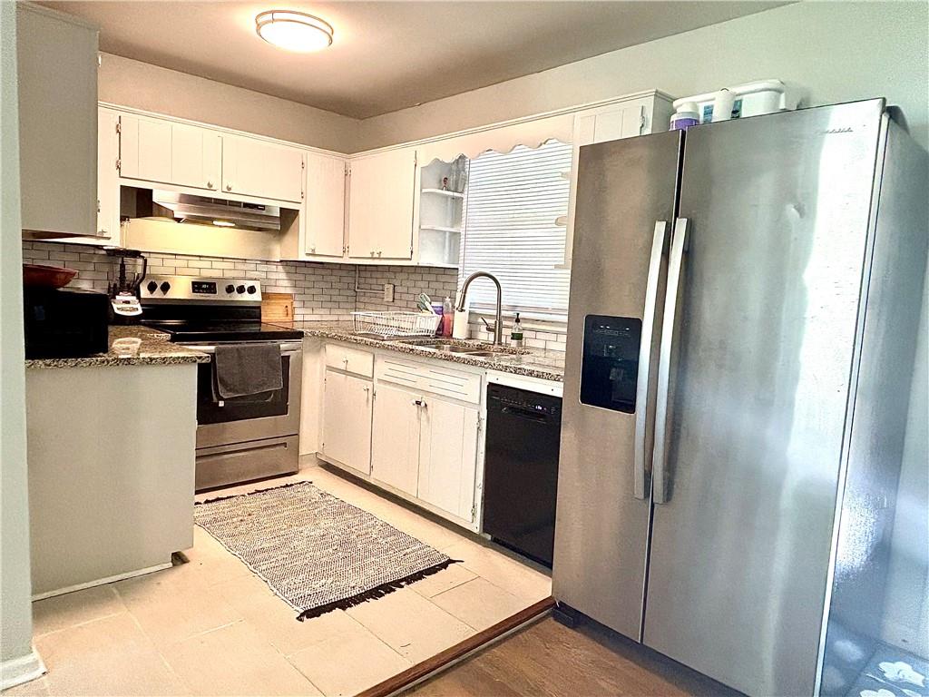 4030 Stonewall Tell Road Atlanta, GA 30349 - Photo 7 of 23 a kitchen with stainless steel appliances granite countertop a refrigerator sink and stove