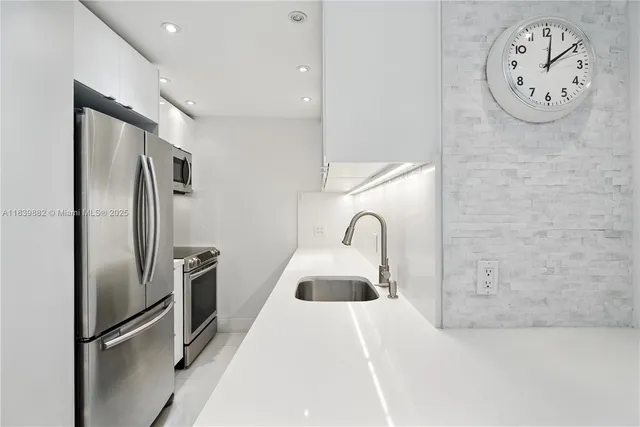 a kitchen with stainless steel appliances granite countertop a refrigerator and a sink