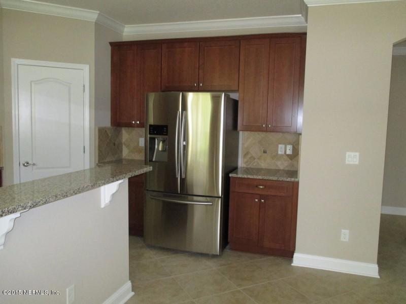 9694 Beauclerc Bluff Road Jacksonville, FL 32257 - Photo 6 of 21 a kitchen with a refrigerator a microwave and cabinets