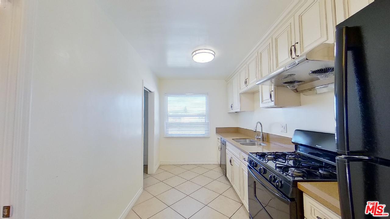 2027 Euclid Street, Unit E Santa Monica, CA 90405 - Photo 5 of 18 a kitchen with stainless steel appliances granite countertop a stove and a refrigerator