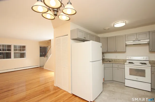 a white refrigerator freezer and a stove sitting inside of a kitchen
