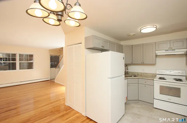 a white refrigerator freezer and a stove sitting inside of a kitchen