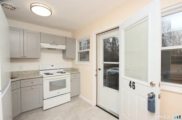 a kitchen with white cabinets and white appliances