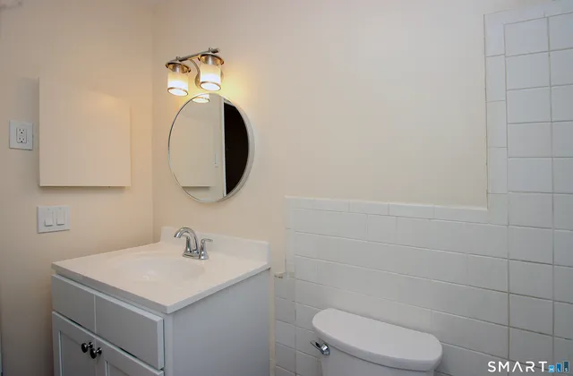 a bathroom with a toilet sink and mirror