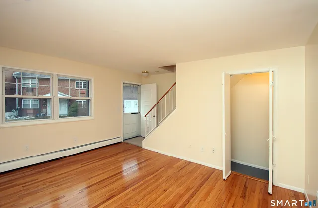 a view of empty room with wooden floor and entryway