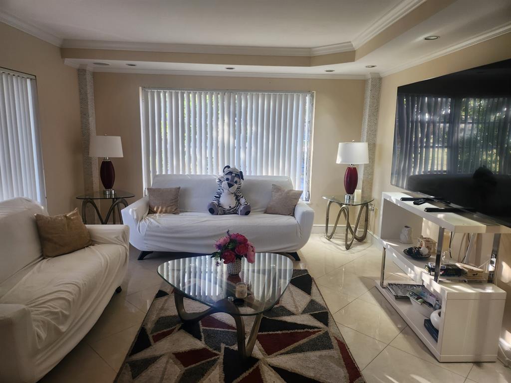 4160 Inverrary Drive, Unit 311 Lauderhill, FL 33319 - Photo 13 of 15 a living room with furniture and a flat screen tv