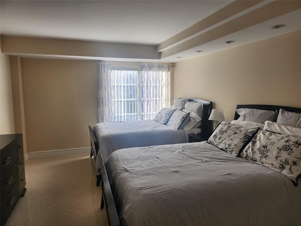 4160 Inverrary Drive, Unit 311 Lauderhill, FL 33319 - Photo 6 of 15 a bedroom with two beds and a window