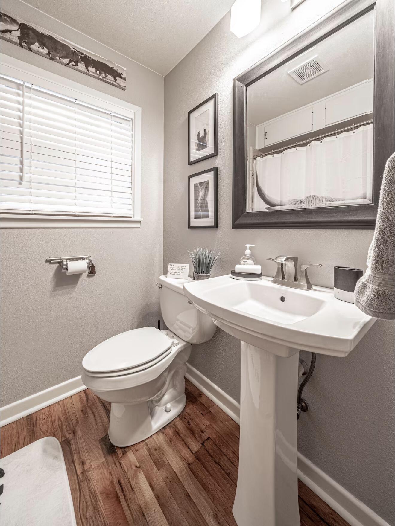 2816 37th Street Lubbock, TX 79413 - Photo 14 of 19 a bathroom with a sink toilet a mirror and shower