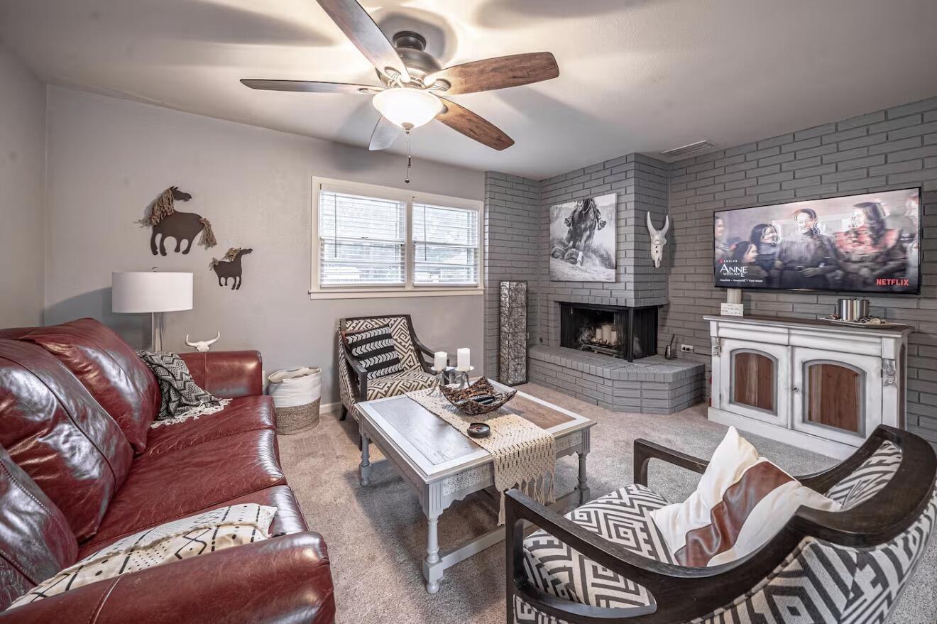 2816 37th Street Lubbock, TX 79413 - Photo 5 of 19 a living room with furniture a fireplace and a flat screen tv