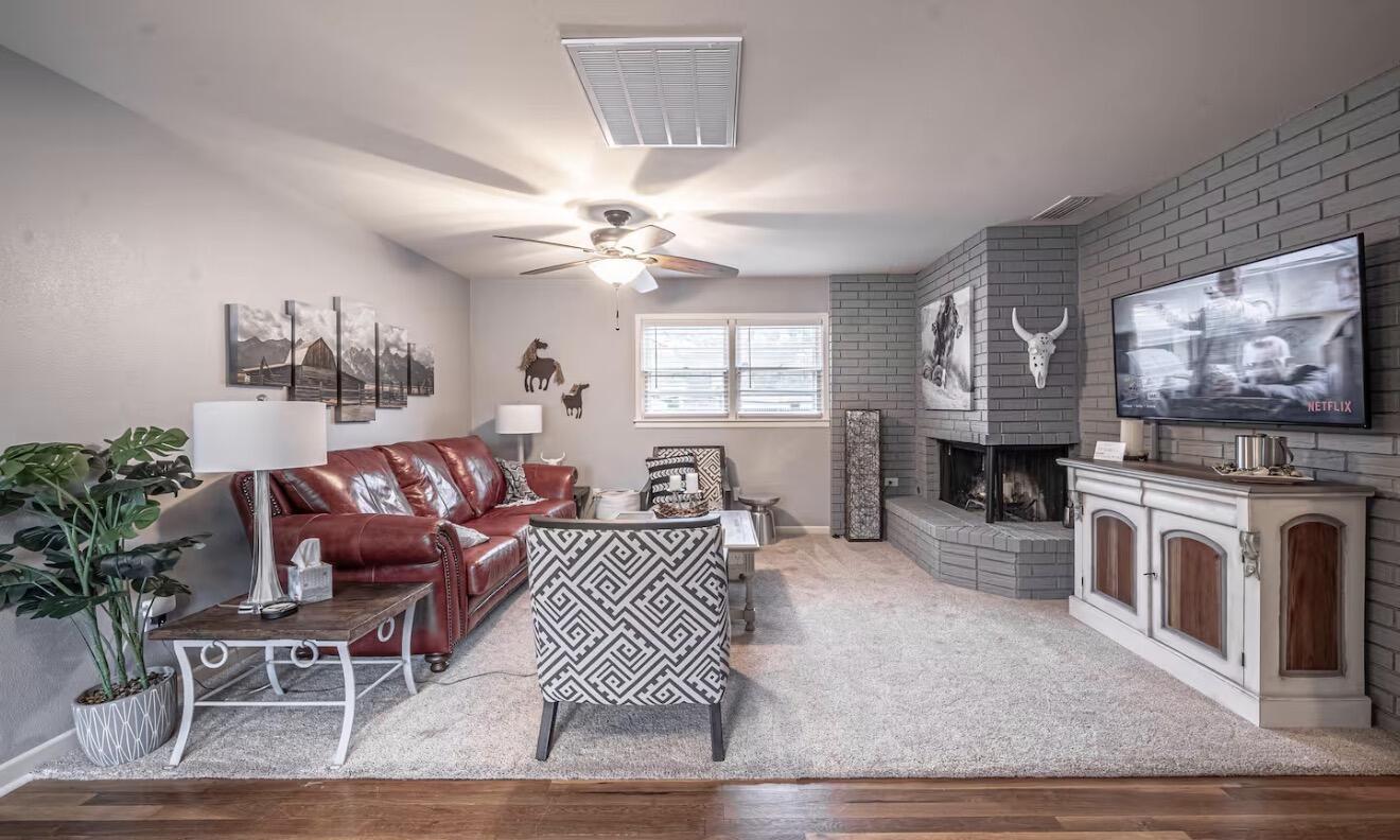 2816 37th Street Lubbock, TX 79413 - Photo 8 of 19 a living room with furniture a flat screen tv and a fireplace