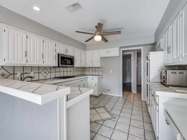 a kitchen with stainless steel appliances granite countertop a sink and cabinets
