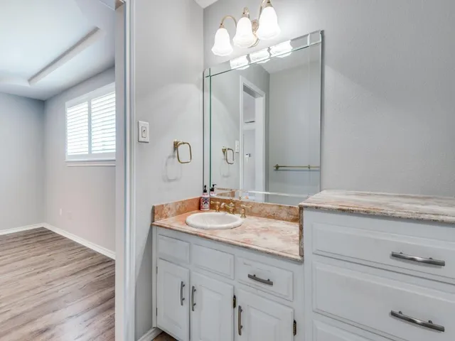 a bedroom with a bed and a mirror on the dresser