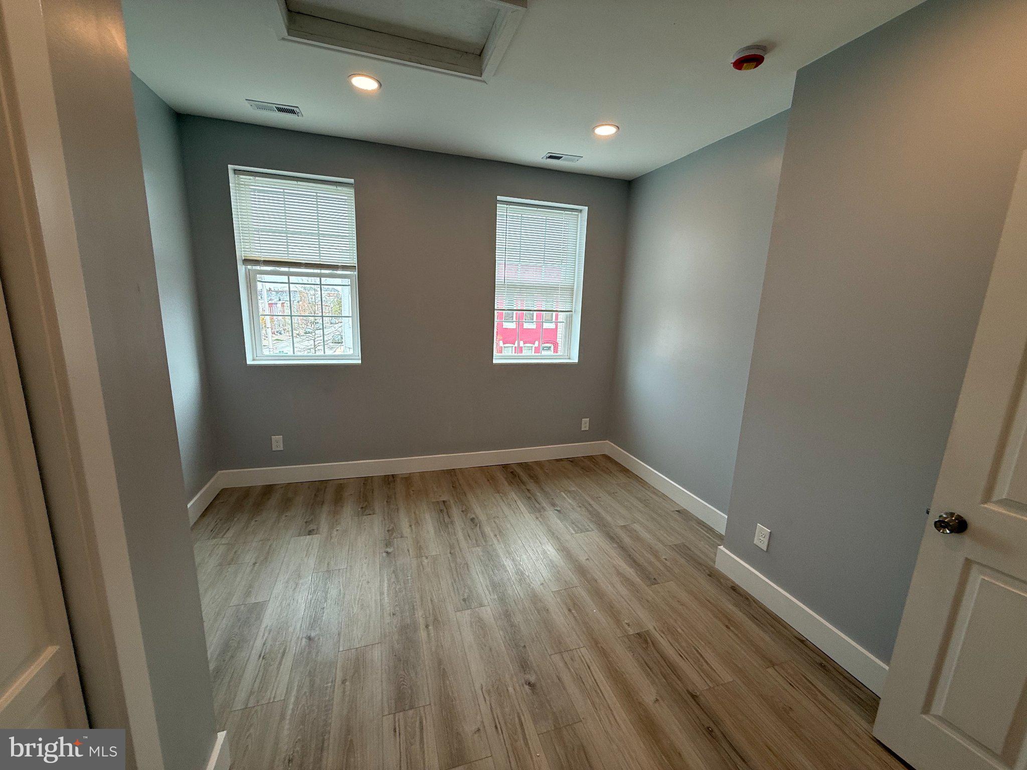 1930 North Payson Street Baltimore, MD 21217 - Photo 6 of 12 an empty room with wooden floor and windows