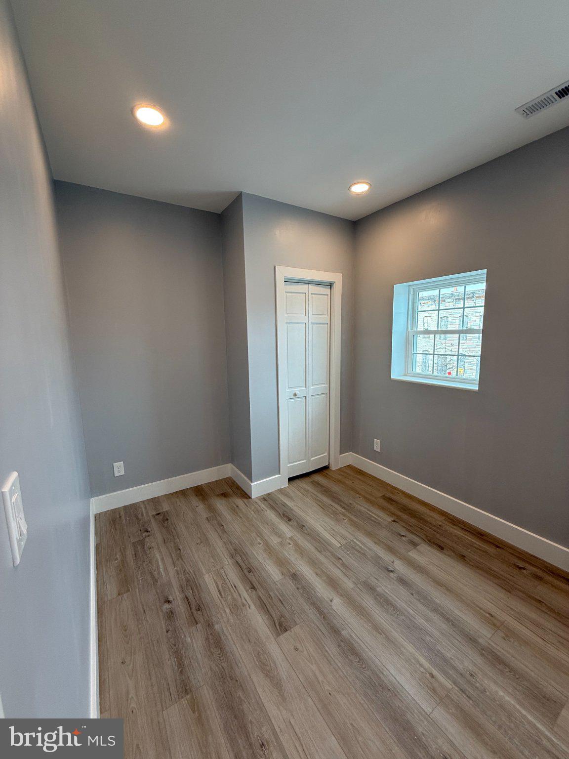 1930 North Payson Street Baltimore, MD 21217 - Photo 9 of 12 a view of an empty room with wooden floor and a window