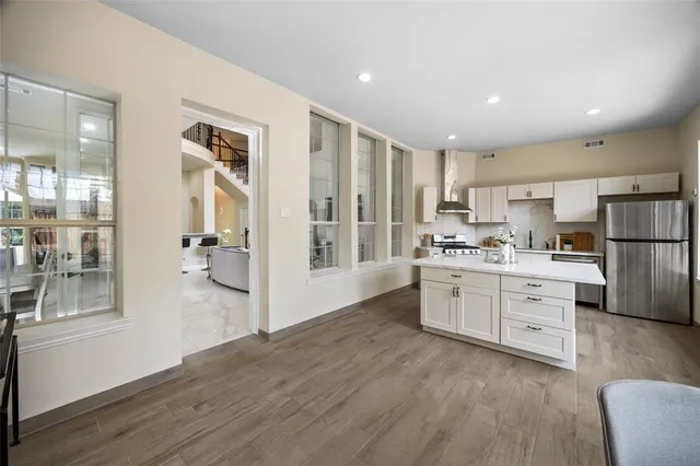 a kitchen with white cabinets and stainless steel appliances