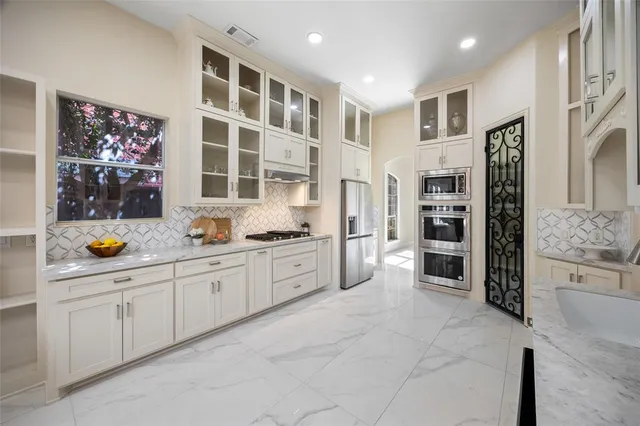 a large kitchen with stainless steel appliances and cabinets