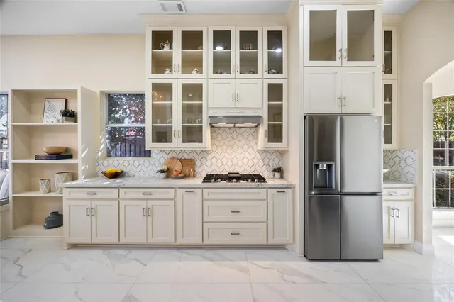 a kitchen with stainless steel appliances granite countertop a refrigerator and a stove