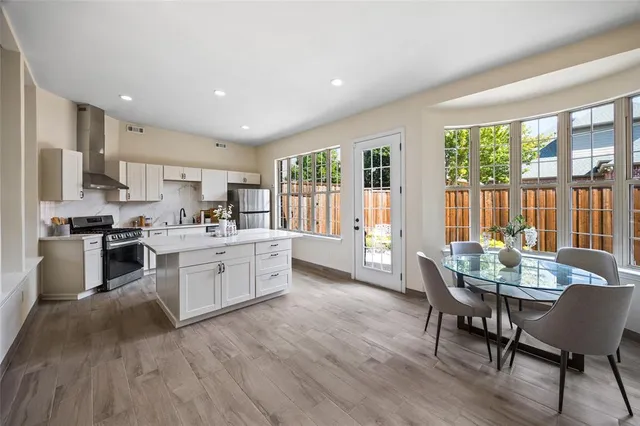 a kitchen with a table chairs sink and cabinets