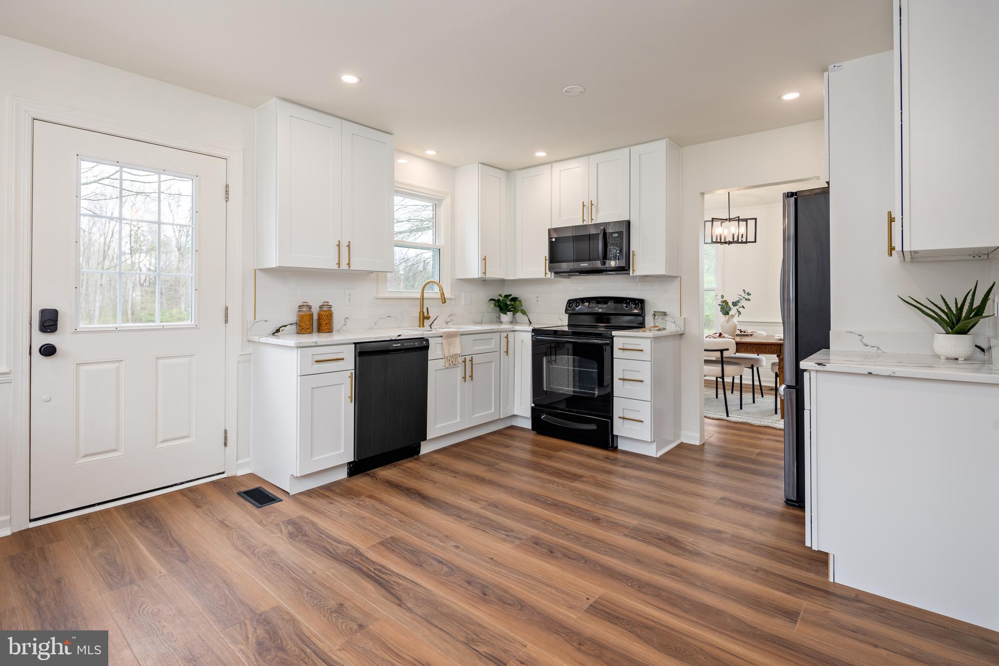 324 Flat Iron Square Road Church Hill, MD 21623 - Photo 7 of 47 a kitchen with stainless steel appliances granite countertop a stove top oven a sink a refrigerator white cabinets and wooden floor