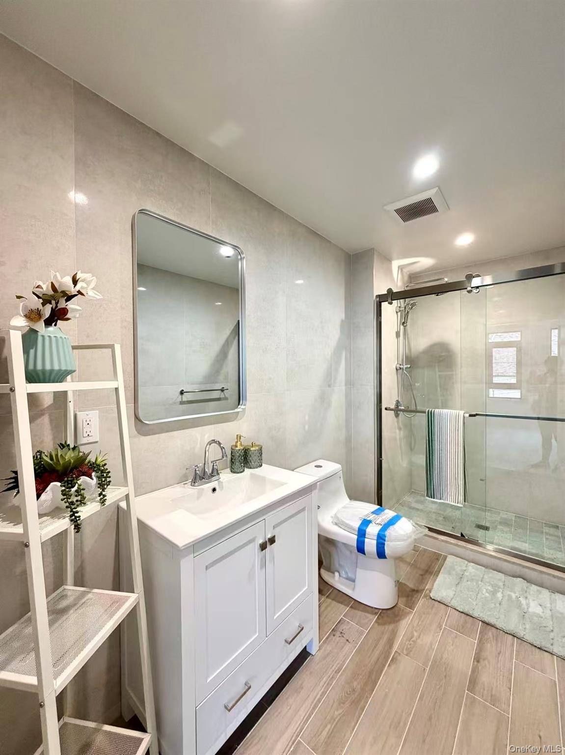 40-09 29th Street, Unit 3A Queens, NY 11101 - Photo 12 of 15 a spacious bathroom with a double vanity sink a mirror and a shower