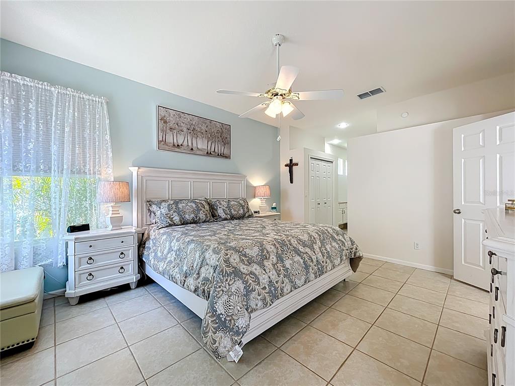 13319 Via Roma Circle Clermont, FL 34711 - Photo 16 of 44 a bedroom with a bed chandelier and a window