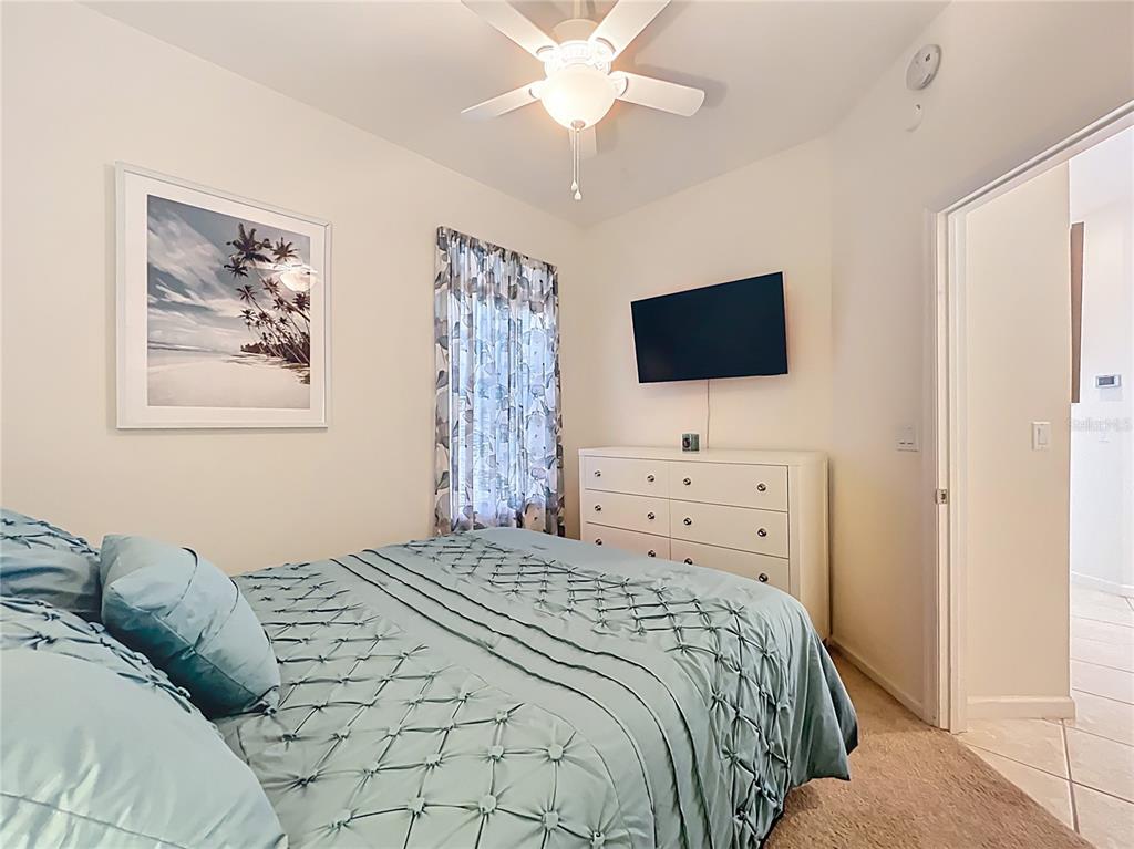 13319 Via Roma Circle Clermont, FL 34711 - Photo 20 of 44 a bedroom with a bed and a flat screen tv