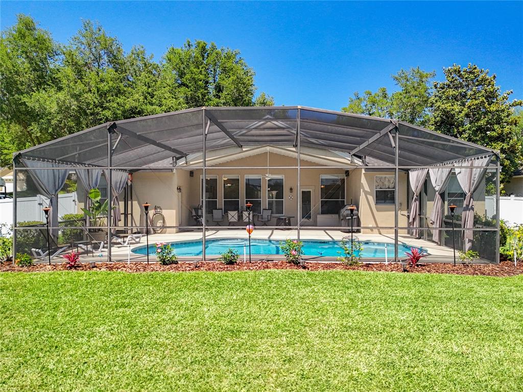 13319 Via Roma Circle Clermont, FL 34711 - Photo 29 of 44 a patio with a table and chairs under an umbrella