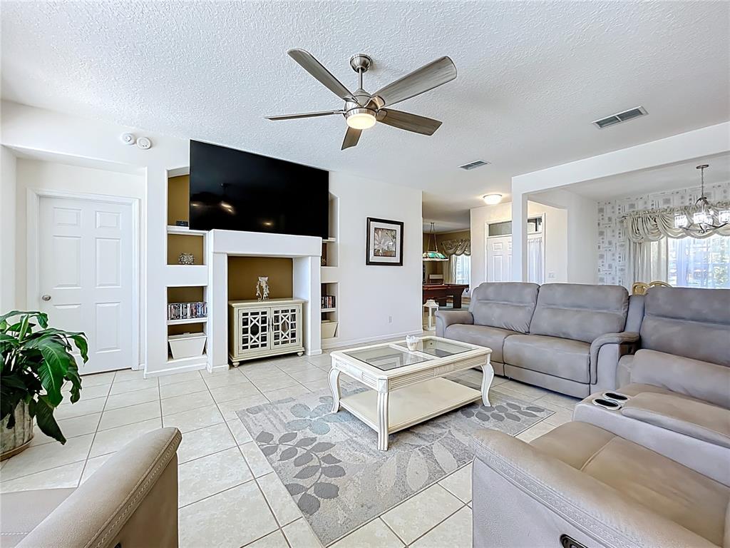 13319 Via Roma Circle Clermont, FL 34711 - Photo 7 of 44 a living room with furniture and a flat screen tv