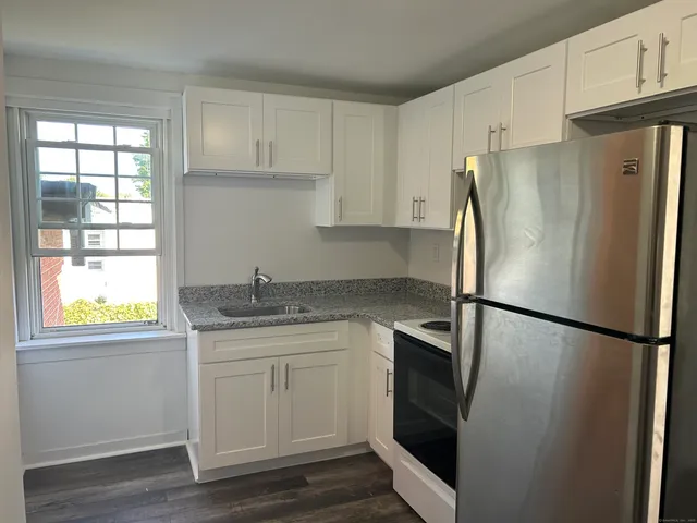 a kitchen with stainless steel appliances a refrigerator sink and cabinets