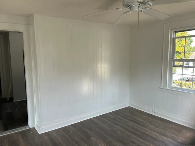 an empty room with a window and wooden floor